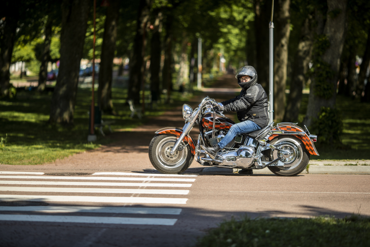 Kvinna på motorcykel som kör i stadsmiljö