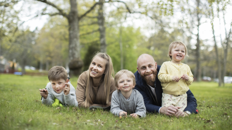 Familj som ligger i gräset