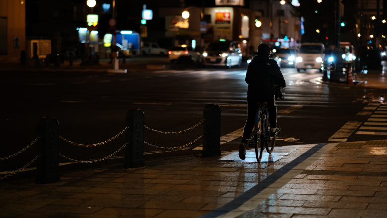 Cyklist som cyklar i mörk stadsmiljö utan reflex