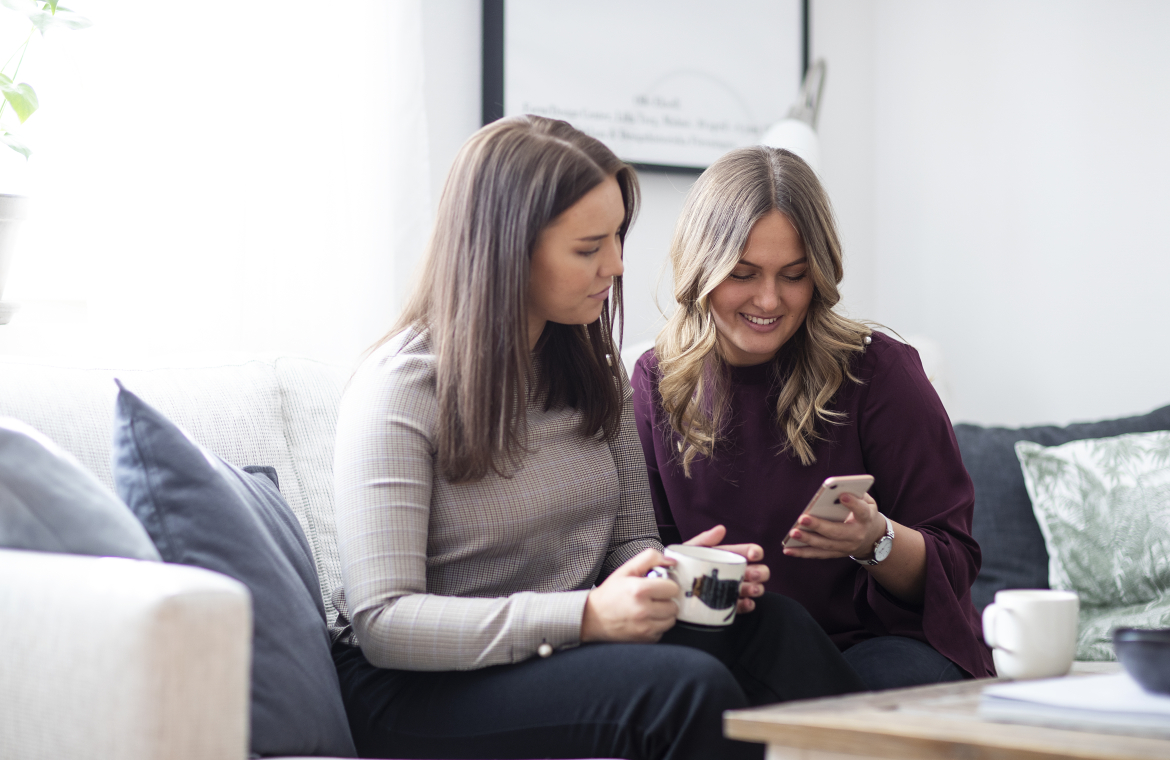 Två tjejer tittar på en mobiltelefon